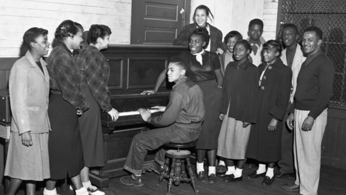 Man at piano surrounded by young people at East White Oak Community Center, 1952