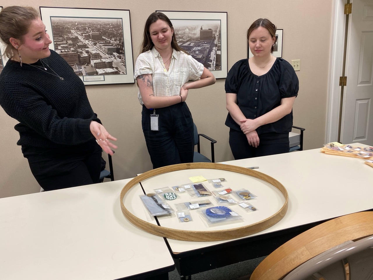 Three young people looking at button display in process